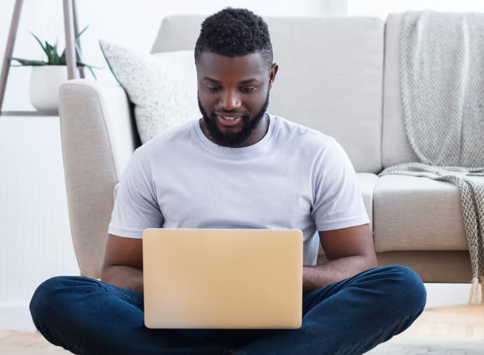Homme assis utilisant un ordinateur portable