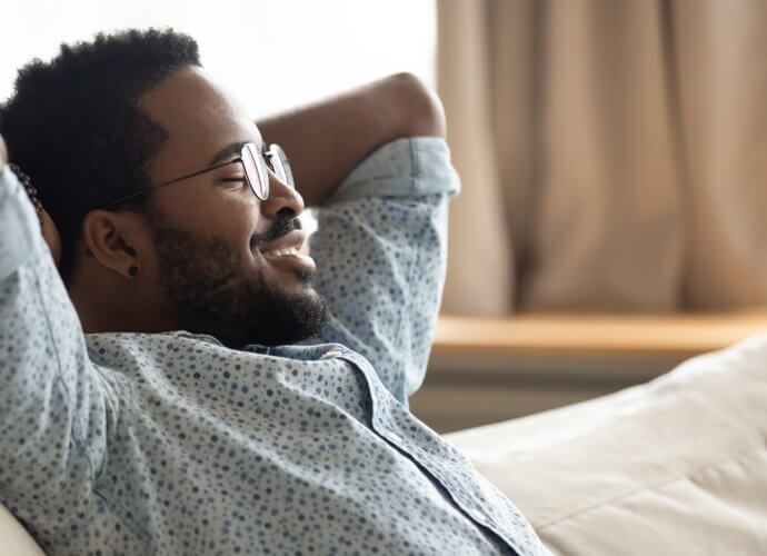Homme souriant assis sur un canapé