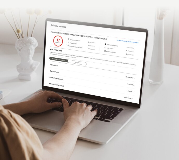 Mains tapant sur un clavier d'ordinateur portable avec Privacy Monitor Assistant à l'écran.